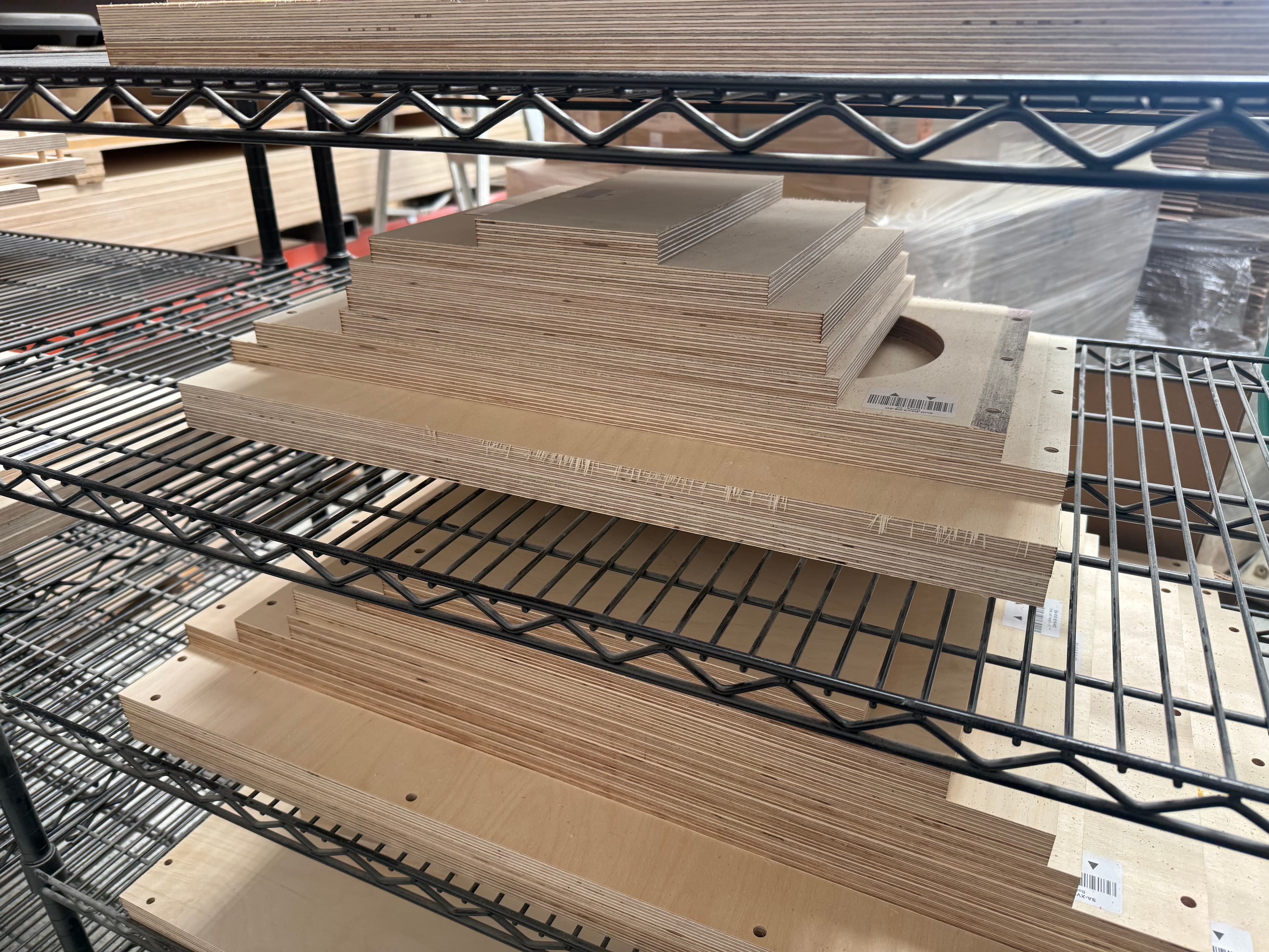 CNC-cut Baltic birch plywood panels stacked on shelving
